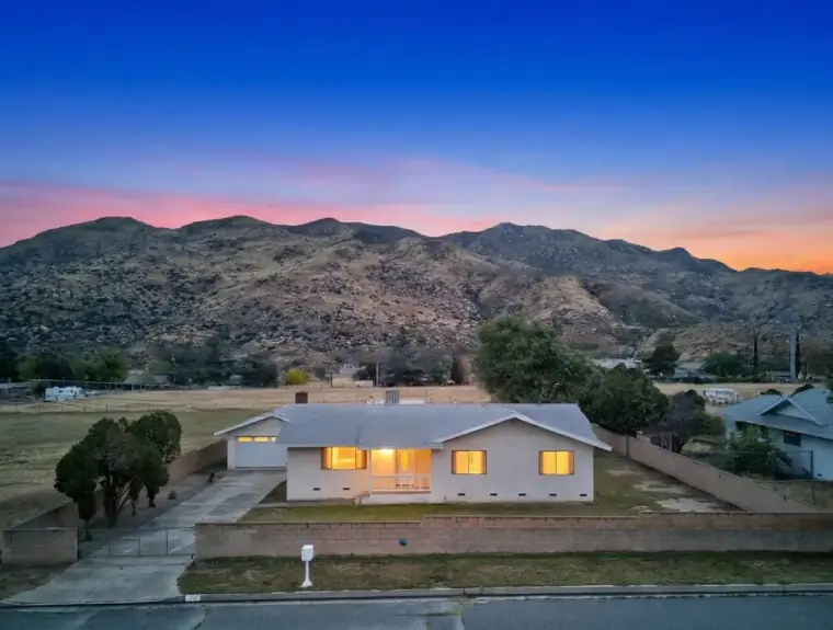 Twilight front elevation with mountain backdrop and warm interior glow — 514 E Victory St, Banning, CA 92220